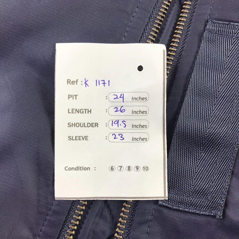 Puede incluir: Una chaqueta azul marino con cierre de cremallera. La chaqueta tiene una etiqueta con las medidas: Pit: 24 pulgadas, Longitud: 26 pulgadas, Hombro: 19,5 pulgadas, Manga: 23 pulgadas. La condici&oacute;n est&aacute; calificada con 8, 9, 10.