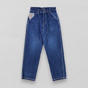 May include: A pair of blue denim jeans with white stitching detail and a small red patch on the front pocket.