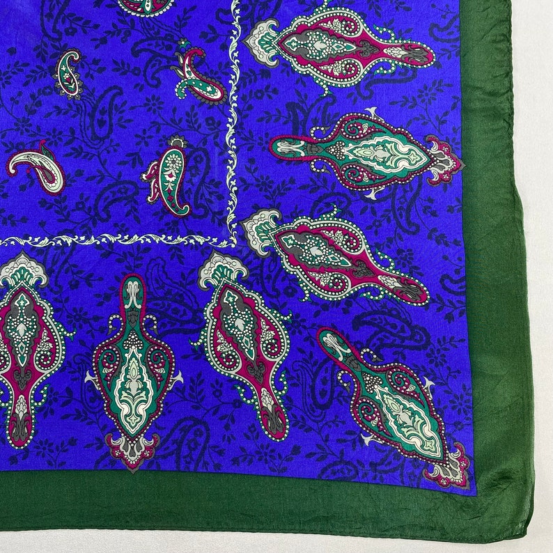 May include: A blue paisley patterned silk scarf with a green border.