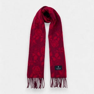 May include: A deep red scarf featuring a tonal rose pattern throughout the fabric. The scarf has a rectangular shape with fringed ends and a black rectangular label near the bottom edge that reads LANVIN COLLECTION in white text.