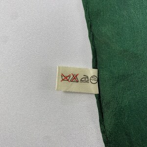 May include: A white care label with four symbols: a washing machine with a cross through it, an iron with a dot inside, a triangle with a cross through it, and a circle with a cross through it.