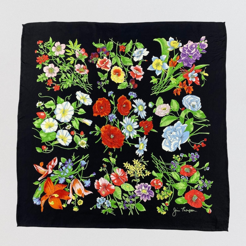 Puede incluir: Pa&ntilde;uelo cuadrado negro con un vibrante estampado floral. El dise&ntilde;o presenta ramos de flores rojas, rosas, blancas, amarillas y azules con hojas verdes. El pa&ntilde;uelo probablemente est&aacute; hecho de seda o un tejido similar.