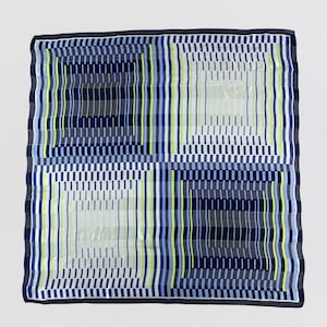 May include: A square scarf featuring a geometric grid pattern divided into four quadrants. The design consists of vertical and horizontal lines in shades of navy blue, light blue, grey, and bright lime green, finished with a dark navy blue border.