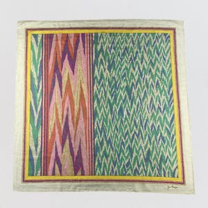 May include: Square silk scarf with a vibrant geometric pattern. The scarf has a cream border with yellow and purple inner borders. The main design features vertical stripes and zig-zag patterns in pink, orange, green, and blue.