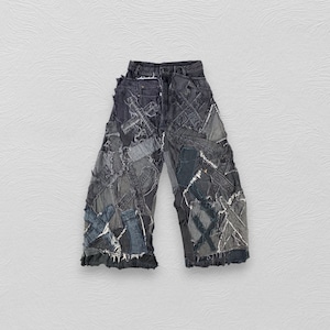 Könnte beinhalten: Schwarze Jeanshose mit mehreren Schichten aus Jeans-Patches, die darauf genäht sind. Die Patches sind in verschiedenen Blautönen und Grautönen gehalten.