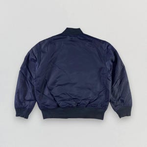 Puede incluir: Una chaqueta bomber azul oscuro con cuello y pu&ntilde;os de canal&eacute;.