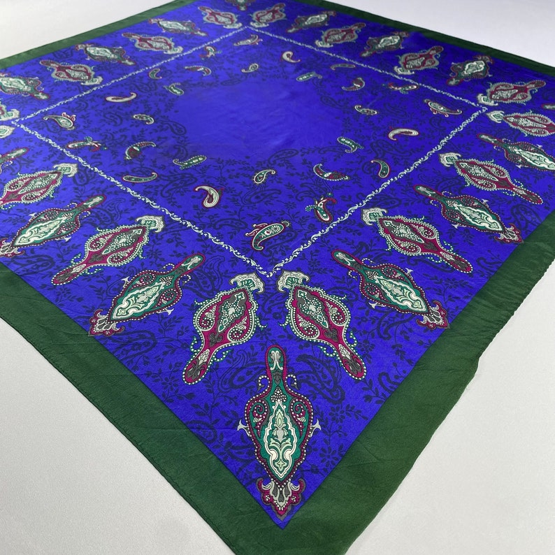 May include: A square blue paisley patterned scarf with a green border.