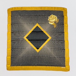 Può includere: Foulard quadrato in seta con un design geometrico nero e oro. La sciarpa presenta una forma a diamante centrale e una rosa dorata nell'angolo in alto a destra. Il bordo è dorato e la sciarpa ha un motivo a righe.