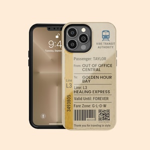 May include: A phone case featuring a vintage-style transit ticket design. The ticket is tan with black text, including "VIBE TRANSIT AUTHORITY," "GOLDEN HOUR BAY," and "HEALING EXPRESS." The phone case is on a black phone, with the time 9:41 displayed.