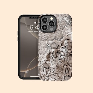 Może przedstawiać: Czarne etui na iPhone z wzorem skóry węża. Etui ma wycięcie na aparat i ochronę ekranu.