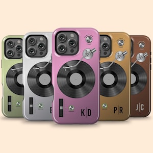 Puede incluir: Una colección de fundas para teléfonos en varios colores, cada una con un diseño de tocadiscos. Las fundas son en tonos de verde, plateado, rosa, dorado y marrón. Cada funda tiene un gráfico de disco negro y un brazo plateado.