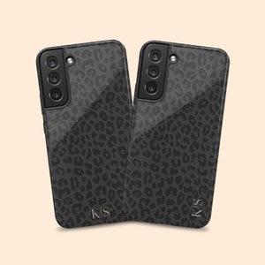 May include: Two black phone cases with a leopard print design and the initials "KS" in gold lettering.