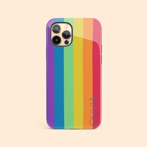 May include: A rainbow striped phone case with a clear back and a camera cutout. The case has the name "Olivia" printed on the back in a blue font.