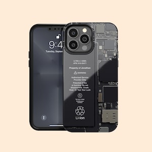 May include: Black iPhone with a clear case showing internal components. The phone displays the time 9:41 on Tuesday, September 13. The case has text that reads "Property of Jonathan" and a warning about potential fire or burning.