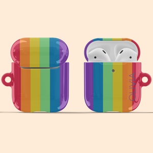 May include: A rainbow-colored protective case for wireless earbuds. The case is open to reveal the earbuds inside. The case has the name "Olivia" printed on the side.