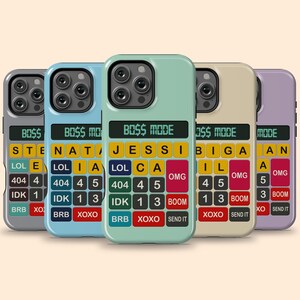 Op de afbeelding: Vijf telefoonhoesjes met een rekenmachine-achtig ontwerp in verschillende kleuren: grijs, blauw, groen, beige en paars. Elk hoesje heeft een scherm met "BOSS MODE" en een toetsenbord met letters en cijfers.