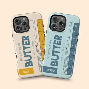 May include: Two phone cases with a butter-themed design. One case is cream-colored and labeled "Sofia's Cream Butter, Salted." The other is light blue and says "Olivia's Cream Butter, Unsalted." Both cases have measurement markings.