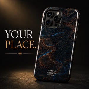 May include: A smartphone case featuring a dark background with intricate orange and blue topographic contour lines. The text "YOUR PLACE." appears to the left, and the case displays "40.7128° N 74.0060° W NEW YORK" at the bottom.