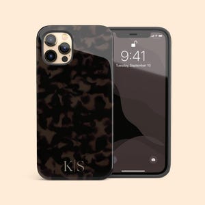 May include: A smartphone case featuring a dark brown and black tortoiseshell pattern with the letters K|S printed in a light serif font at the bottom. The case is shown on a smartphone displaying a lock screen with the time 9:41 and date Tuesday, September 10.