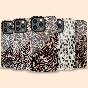 May include: Five different iPhone cases with a leopard print design. The cases are all black and brown with a variety of leopard print patterns.