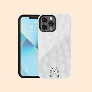 May include: White phone case with a golf ball texture and a black golf club logo with the letters "D" and "S" on a white background.