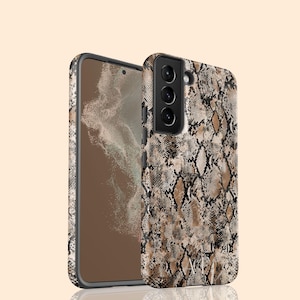 Może przedstawiać: Czarne etui na telefon z brązowym i czarnym wzorem skóry węża. Etui ma wystający element z trzema obiektywami aparatu.