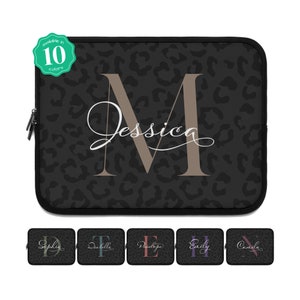 Könnte beinhalten: Schwarze Laptoptasche mit Leopardenmuster und dem Namen "Jessica" in kursivschrift. Das Initial "M" ist in größerer Schrift und beige. Die Tasche ist in 10 Farben erhältlich.