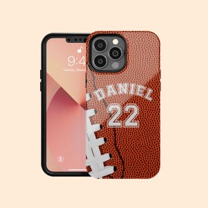 May include: A brown and white football phone case with the name "DANIEL" and the number "22" printed on it.