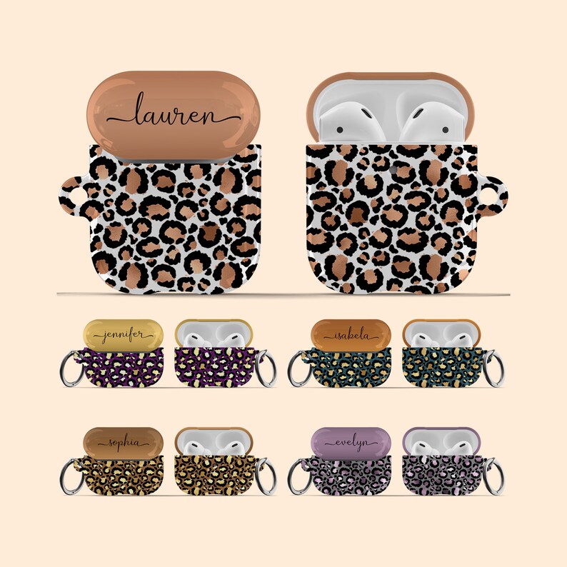 May include: Set of 6 personalized Airpod cases with a leopard print design. The cases are available in different colors and feature a gold-colored metal ring with a keychain. The names "Lauren", "Jennifer", "Isabella", "Sophia", "Evelyn" are written on the cases.