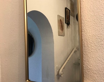A vintage wall mirror in gold from the 70s