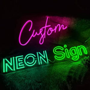 May include: Custom neon sign with the words "Custom" in pink and "Neon Sign" in green.