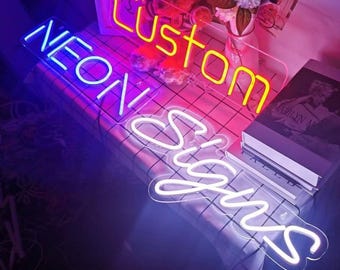 May include: Three neon signs with the words "Custom", "Neon", and "Signs" in different colors. The "Custom" sign is yellow, the "Neon" sign is purple and blue, and the "Signs" sign is white.
