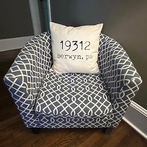 May include: A blue and white patterned armchair with a white pillow that says "19312 Berwyn, PA".
