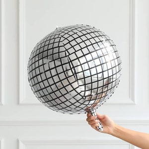 May include: A silver disco ball shaped balloon with a grid pattern.