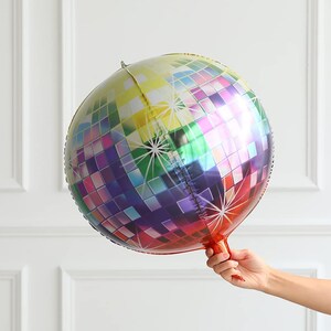 May include: A large, round, iridescent disco ball balloon with a rainbow pattern. The balloon is made of mylar and has a self-sealing valve.