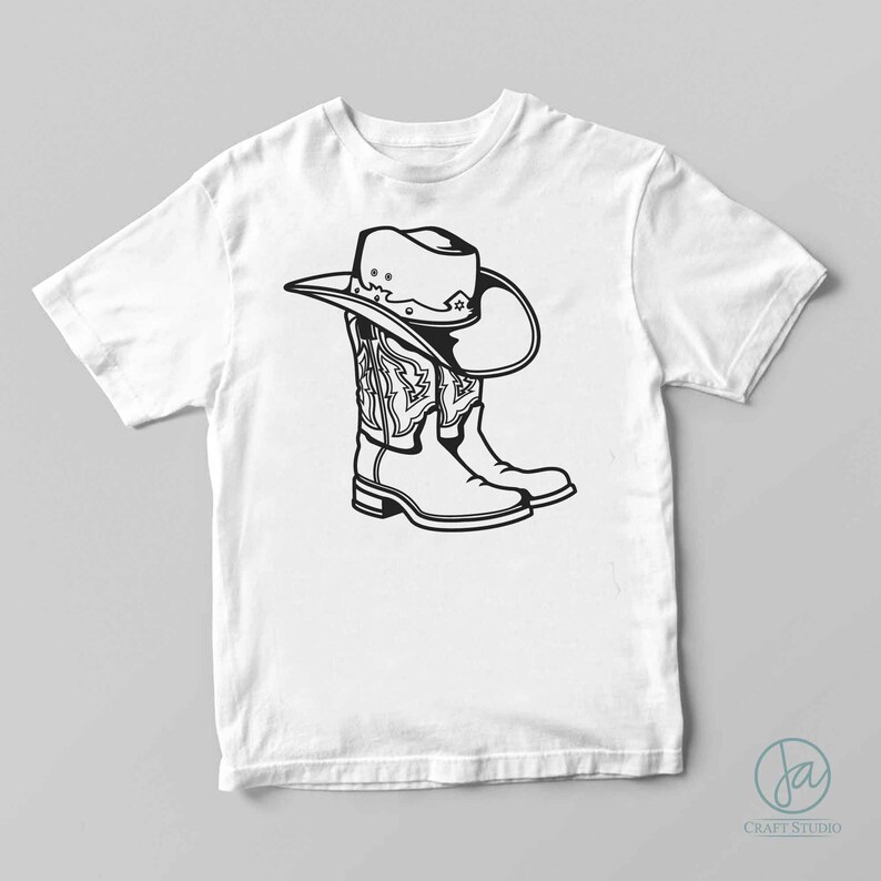 May include: A white t-shirt with a black and white illustration of a cowboy hat and boots.