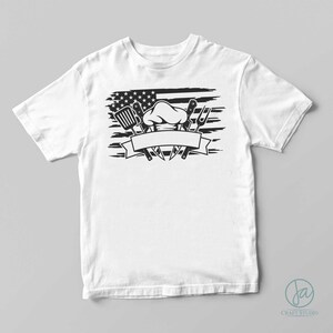 May include: White t-shirt featuring a black and white graphic of a chef's hat, kitchen utensils, and an American flag.