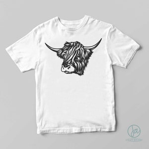 May include: A white t-shirt with a black and white illustration of a Highland cow's head.