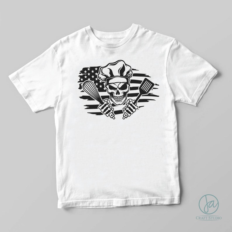 May include: White t-shirt with a black and white graphic of a skull wearing a chef's hat and holding a whisk and spatula. The skull is in front of a distressed American flag.