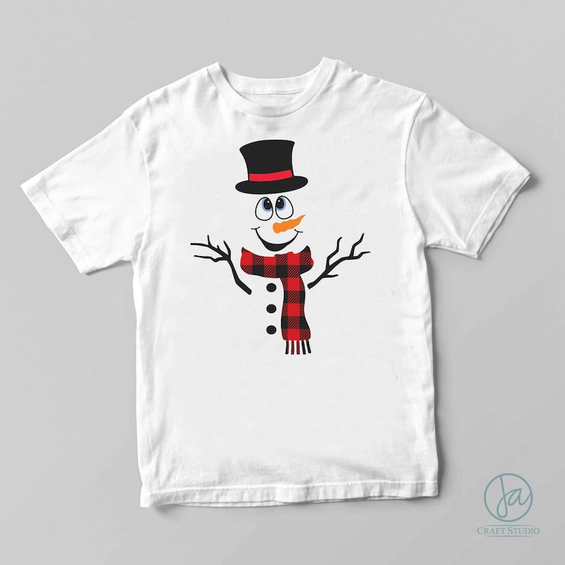K&ouml;nnte beinhalten: Wei&szlig;es T-Shirt mit einem Cartoon-Schneemann, der einen schwarzen Zylinder mit rotem Band, einen rot-schwarz karierten Schal und eine schwarze Knopfnase tr&auml;gt.