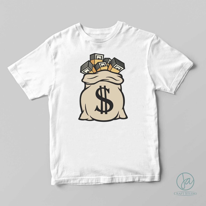 Op de afbeelding: Wit t-shirt met een cartoon illustratie van een beige geldbuidel met een groot zwart dollarteken. De tas stroomt over van stapels goudkleurig geld. Het ontwerp is gecentreerd op het shirt.