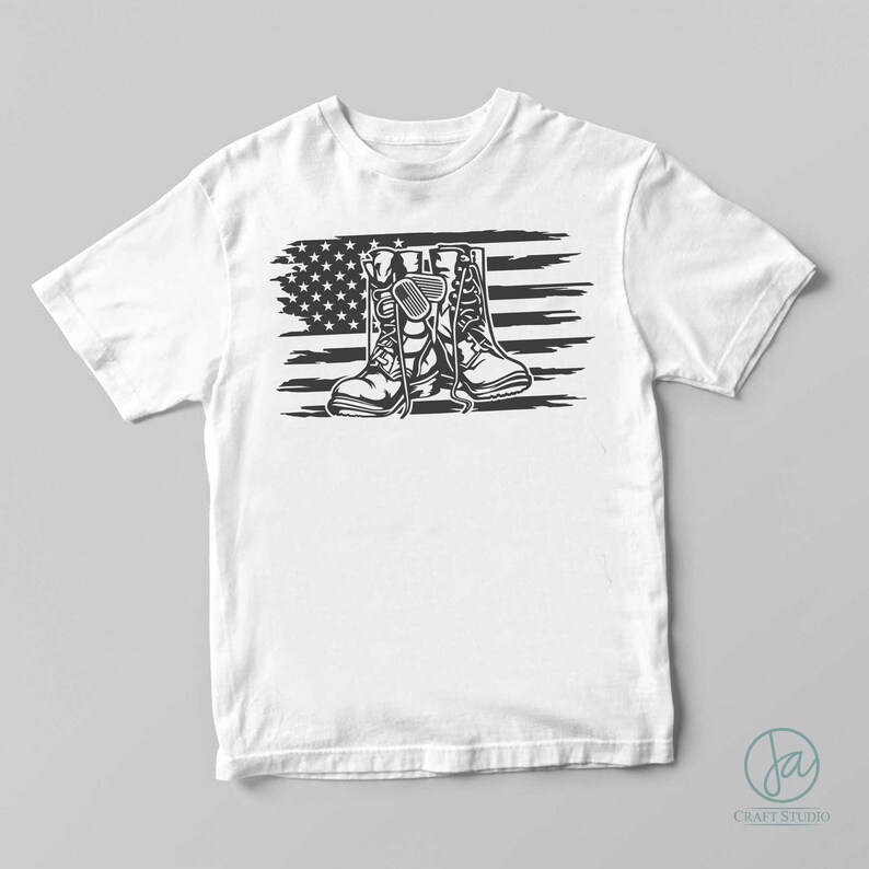 May include: White t-shirt with a black and white graphic of military boots and an American flag.