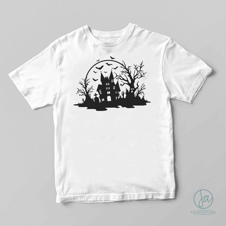 May include: A white t-shirt with a black silhouette of a haunted house, trees, and bats in front of a full moon.