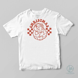 May include: White t-shirt with a red graphic of Santa Claus with the text "Christmas vibes" in a retro style.