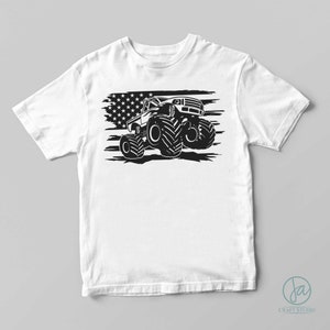 May include: A white t-shirt with a black and white graphic of a monster truck driving over an American flag.