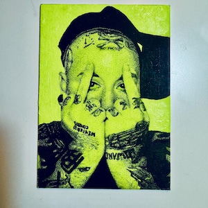 May include: A neon green portrait of a person with tattoos and a black hat. The person's hands are up, covering their face. The image has the words "Wizards" and "No Photo" visible.