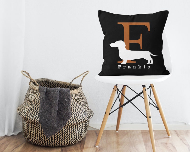 May include: Black and white throw pillow with a white dachshund silhouette and the letter "F" in brown. The pillow has the name "Frankie" printed in white below the dachshund.