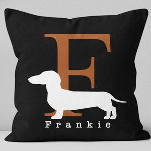 May include: Black throw pillow with a white dachshund silhouette and the letter "F" in orange. The text "Frankie" is printed below the dachshund.