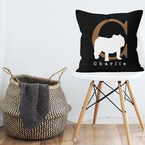 May include: Black and white pillow with a brown letter C and a white silhouette of a bulldog. The pillow has the name "Charlie" printed on it.