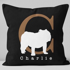 May include: Black pillow with a brown letter C and a white silhouette of a bulldog. The pillow has the name "Charlie" printed on it.